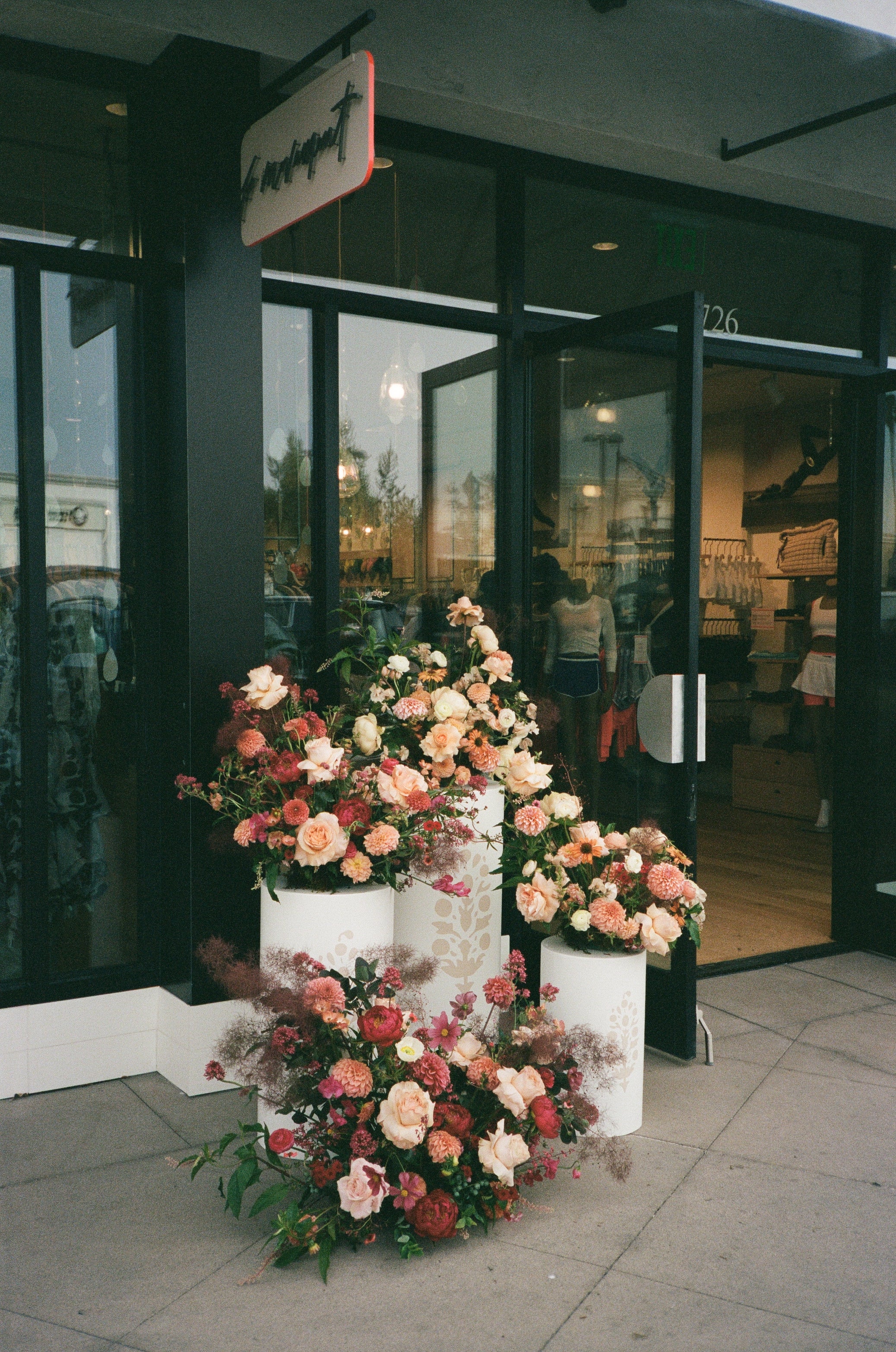 Floral arrangement on a table with a reflective floor and glass door in the background