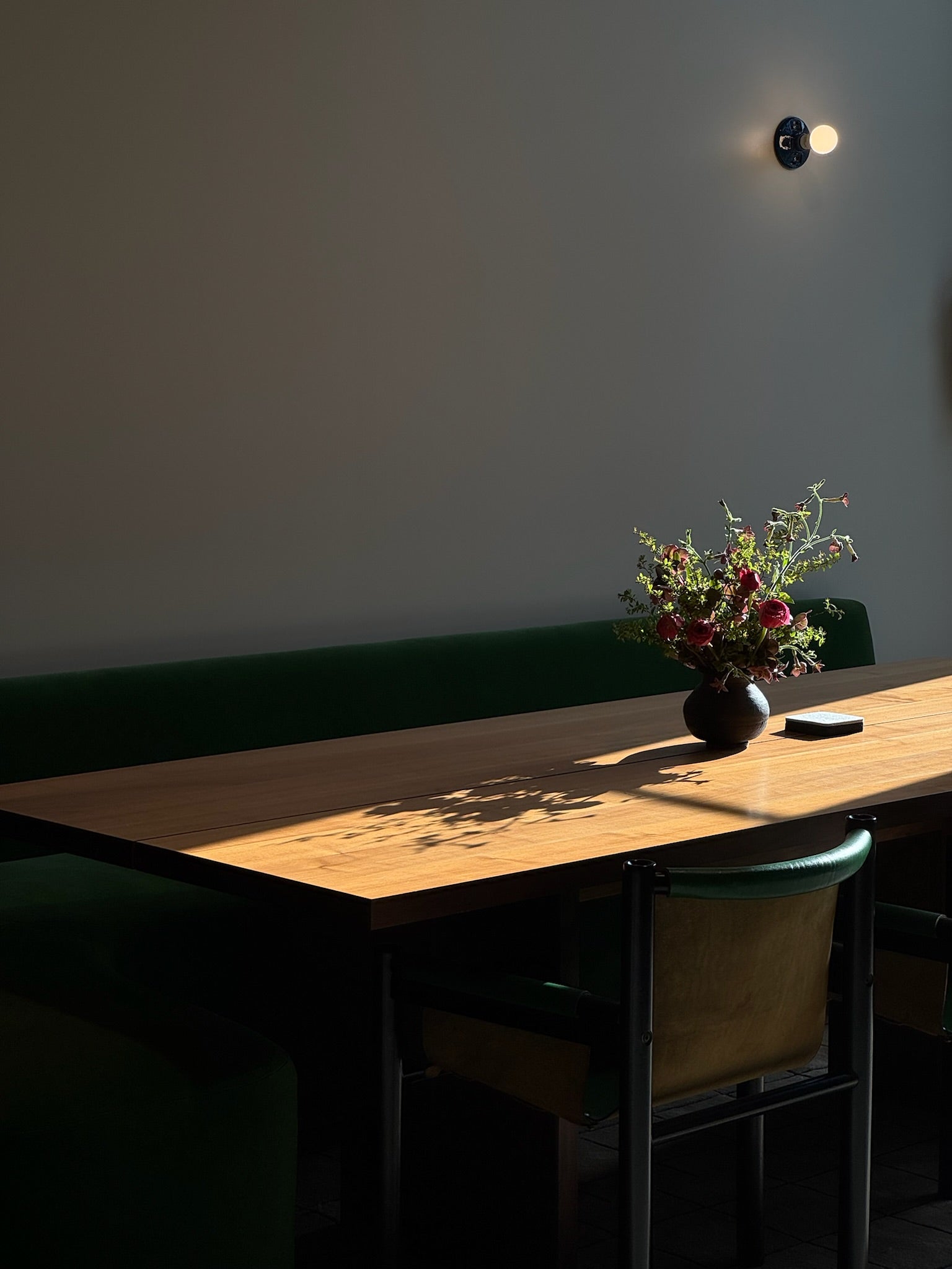 Wooden table with a vase of flowers in a dimly lit room